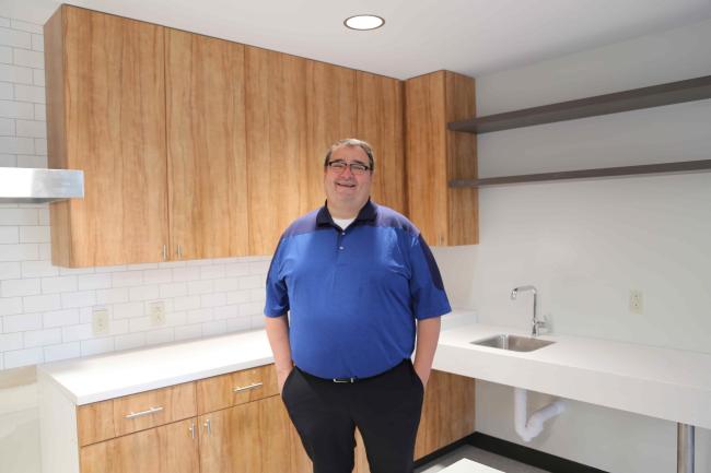 Man standing in kitchen of residence hall