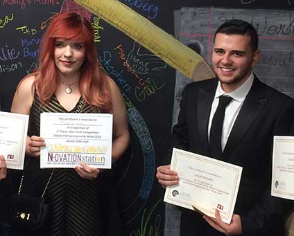 Two students holding award certificates