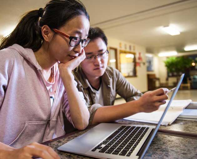 Two students looking at laptop