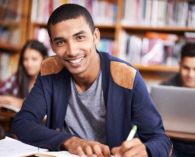Student smiling while taking notes