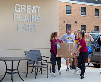Students move a box into Great Plains East