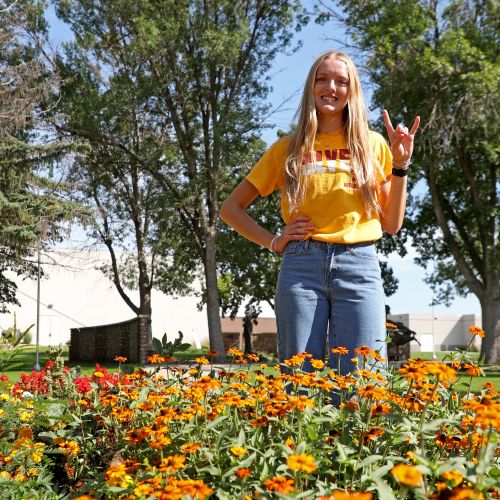 Abby Kolousek surrounded by orange flowers