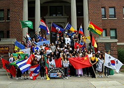 Students take a picture with flags in front of Graham Hall
