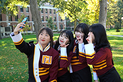 Exchange students take a selfie in marching band attire