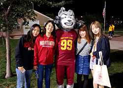 Exchange students take a photo with Thunder the wolf