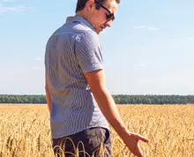 Student standing in a field of wheat