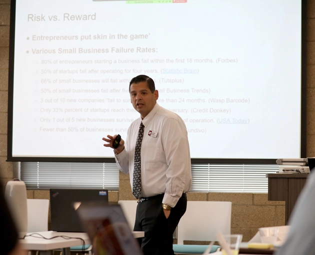 Male Professor Teaching in front of a projector screen