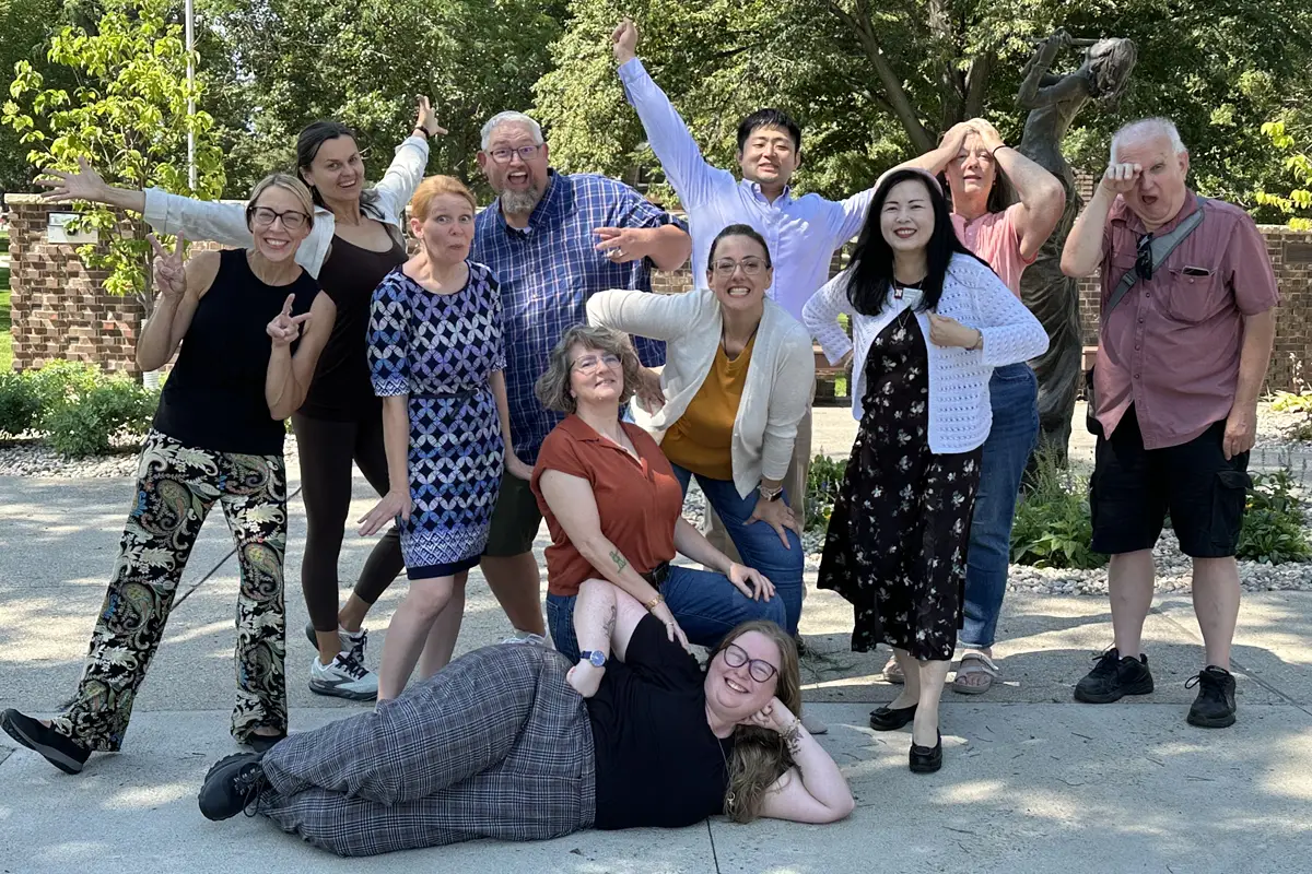 Photo of the department faculty standing outside doing goofy poses