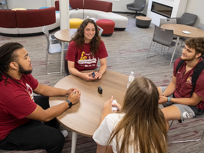 Four students gathering around a table