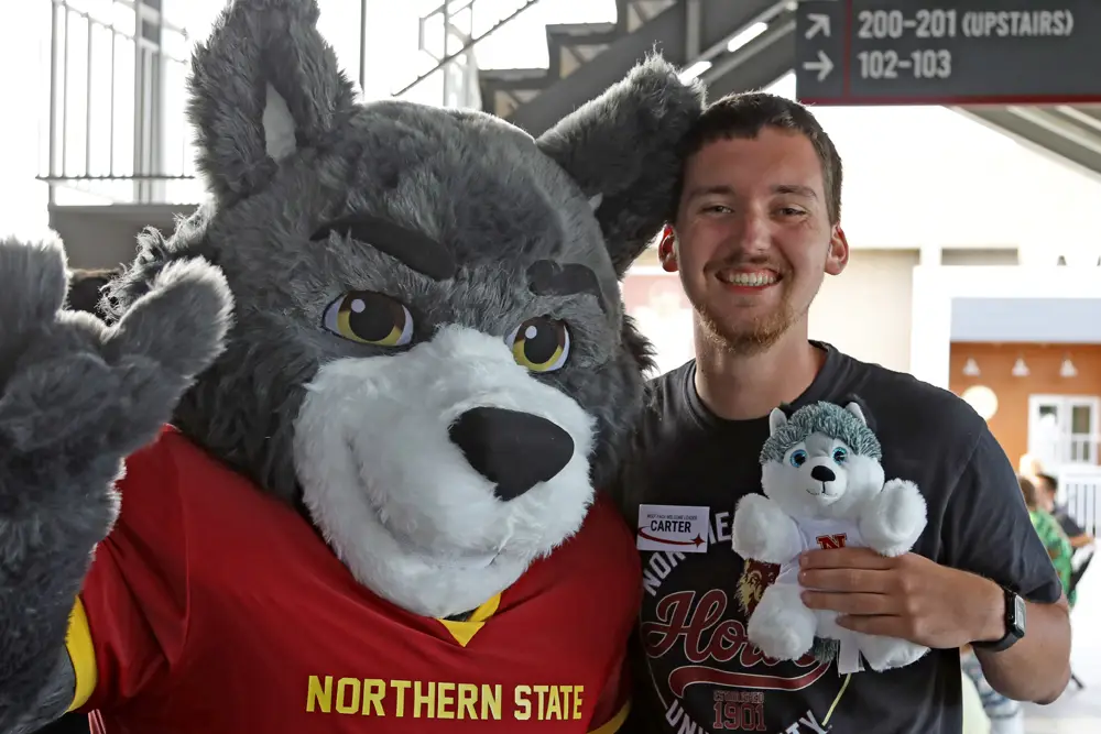 Thunder Mascot posing with a student