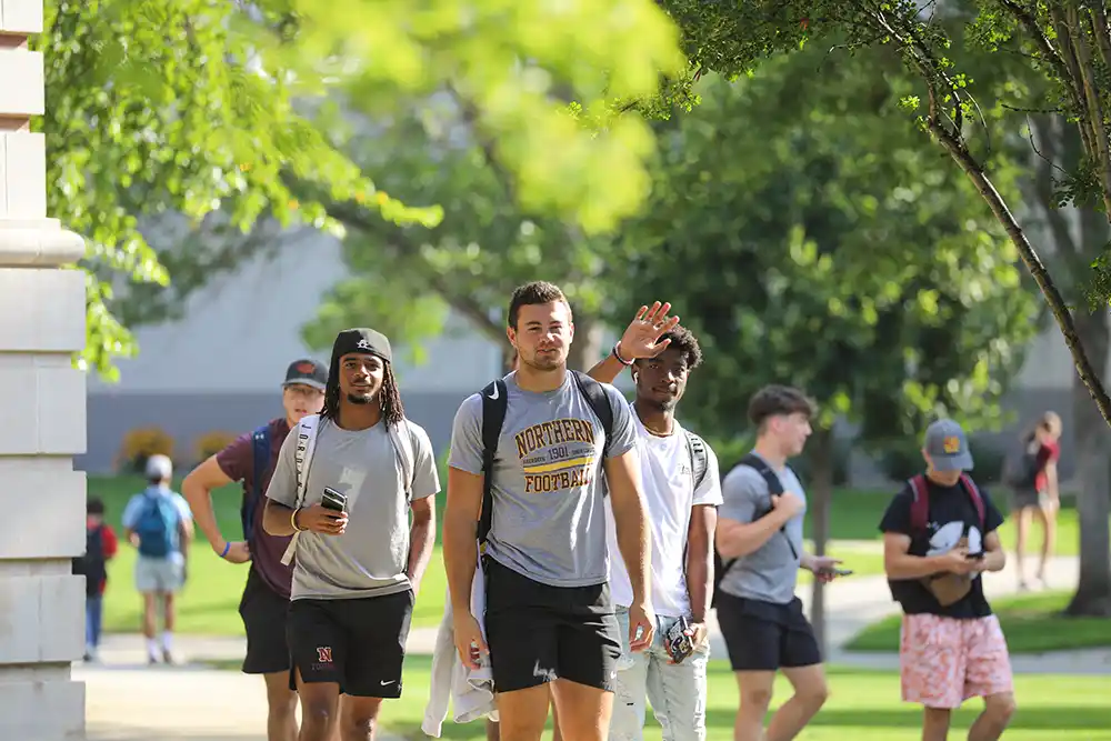 Students walking on a sidewalk on the NSU campus