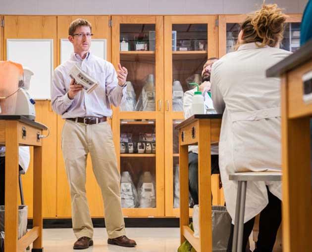 An instructor talks to a chemistry class