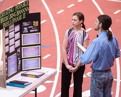 Attendees view a science fair exhibit in the Barnett Center
