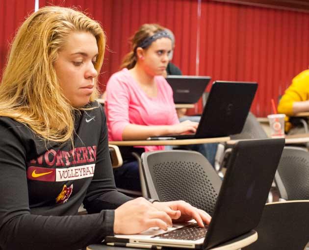 Students type on laptops