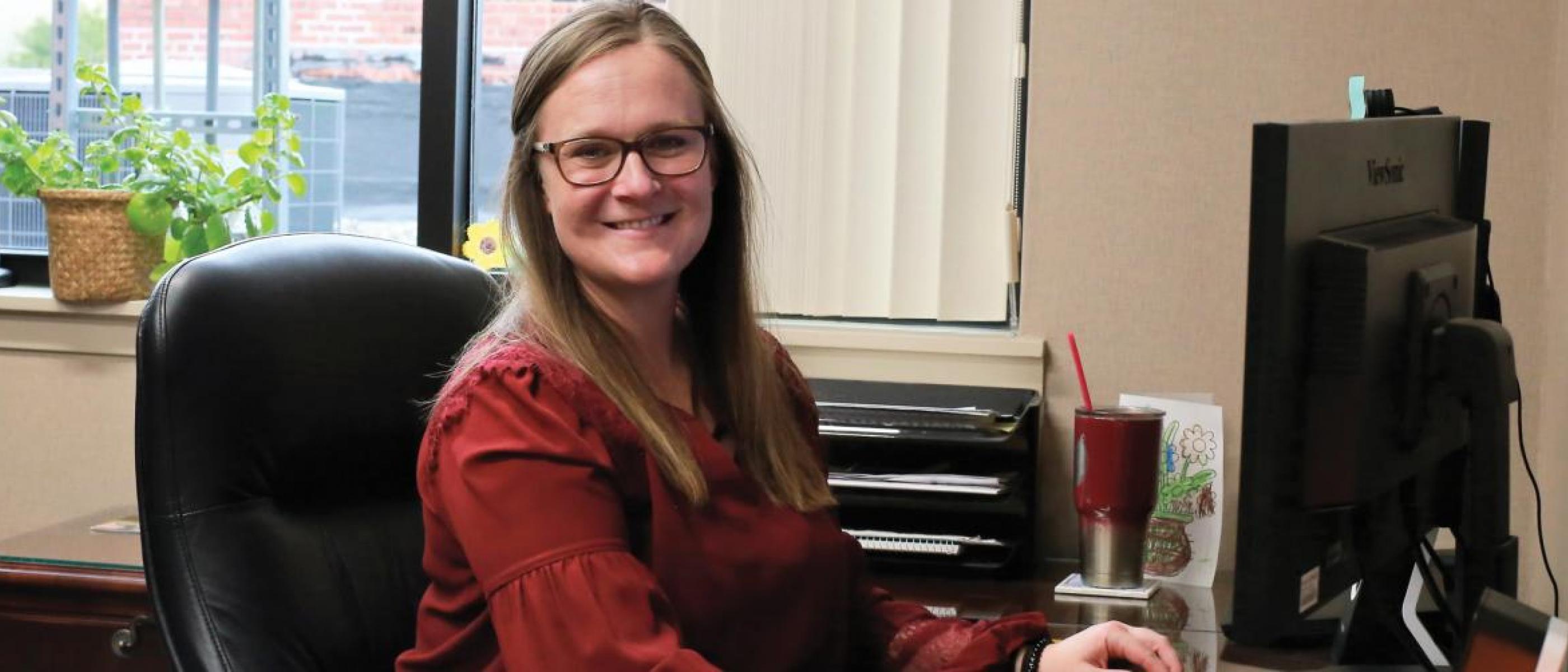 Female alum sitting at her desk.