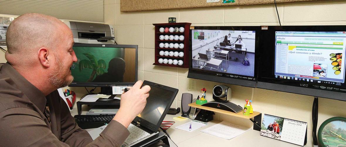 Teacher using computer screens to teach to students at a distance