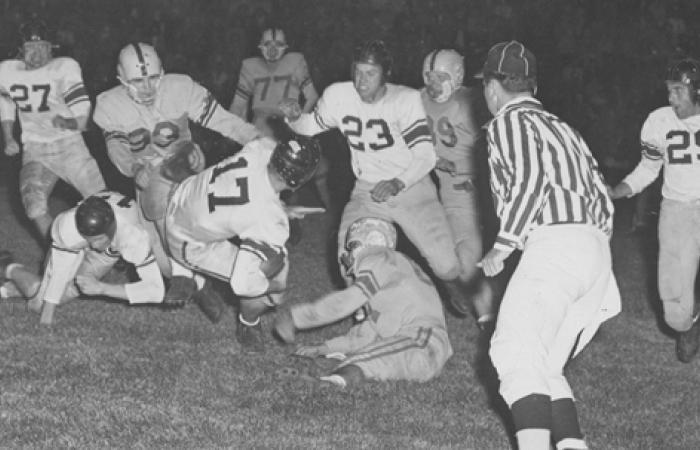 Black and white photo of football players on field
