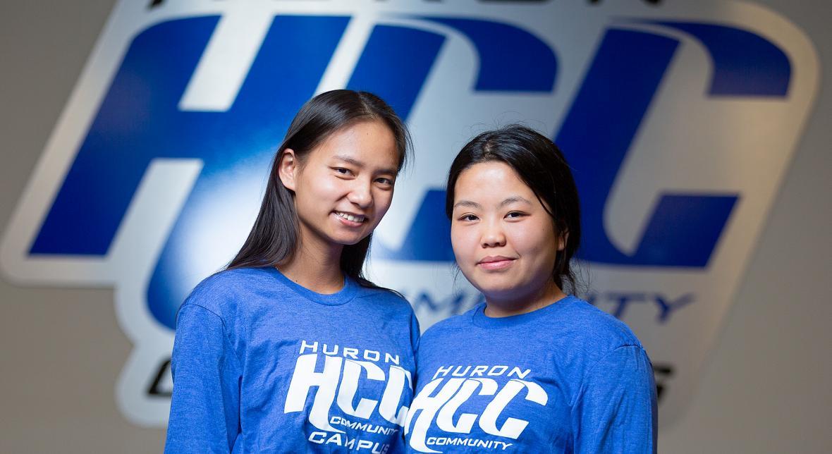 Two students in HCC shirts smile