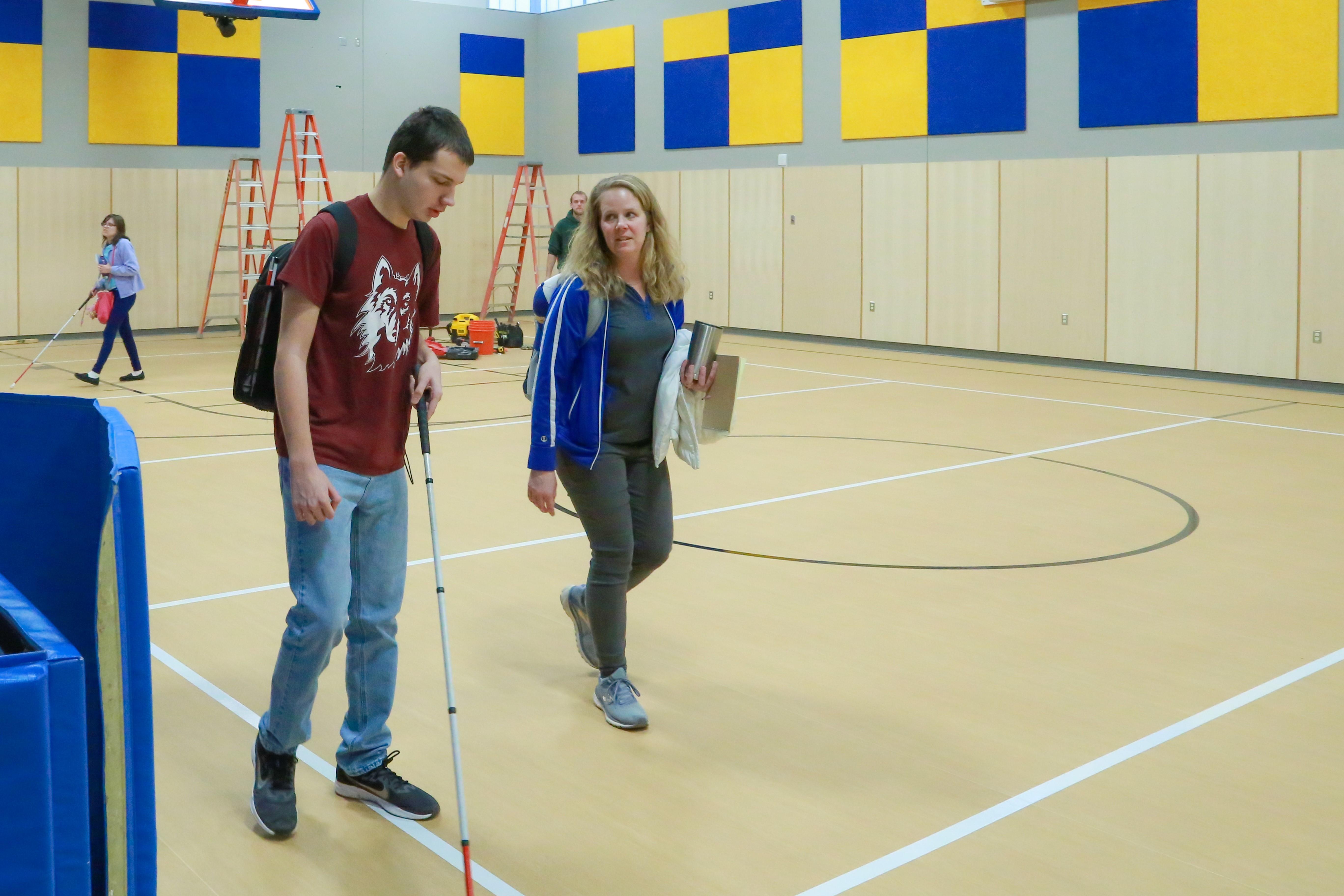 Students and teacher walking through gym