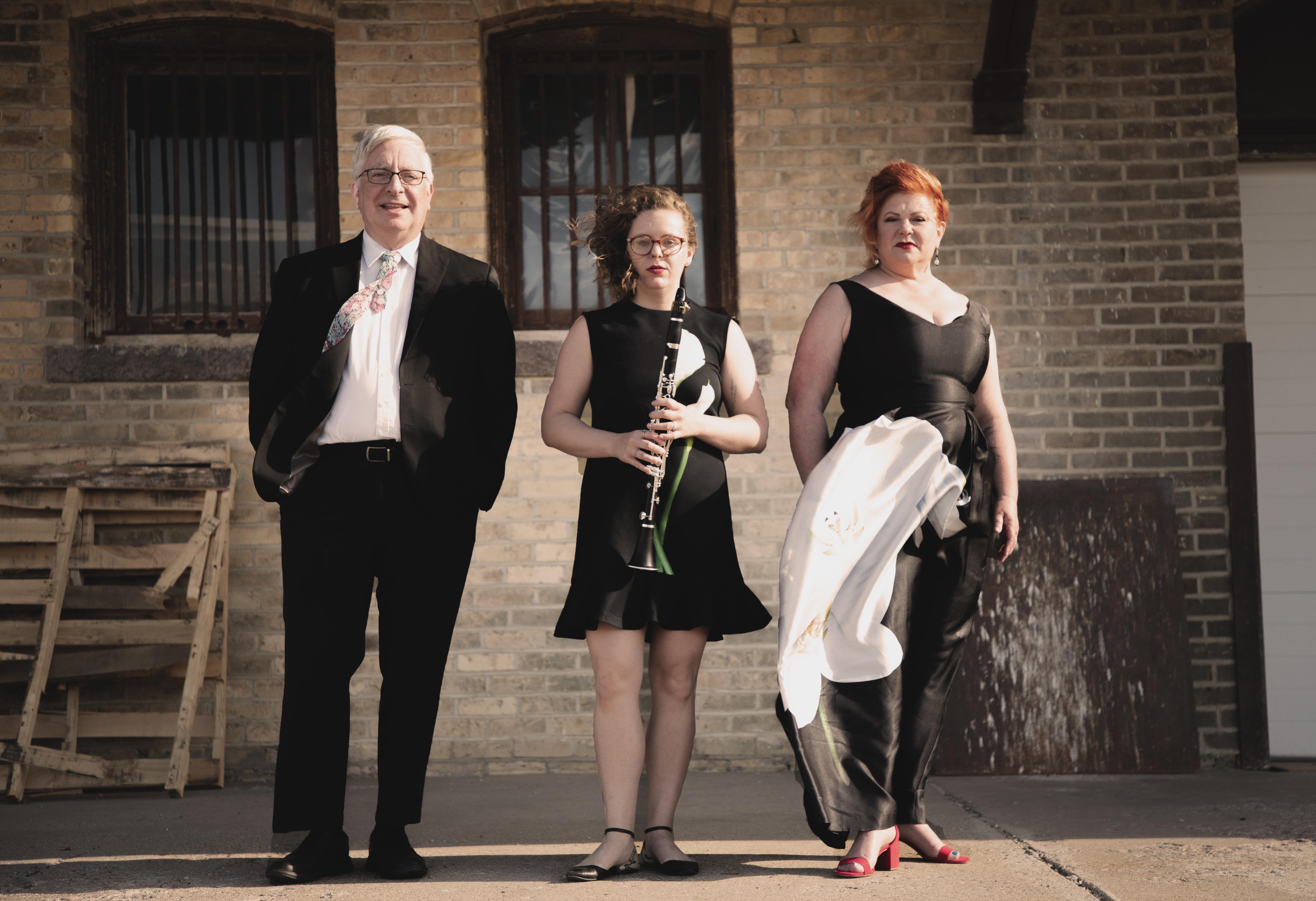 Three musicians standing outside a building