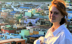 Student Demi Waldner standing on a balcony overlooking colorful buildings in South Korea