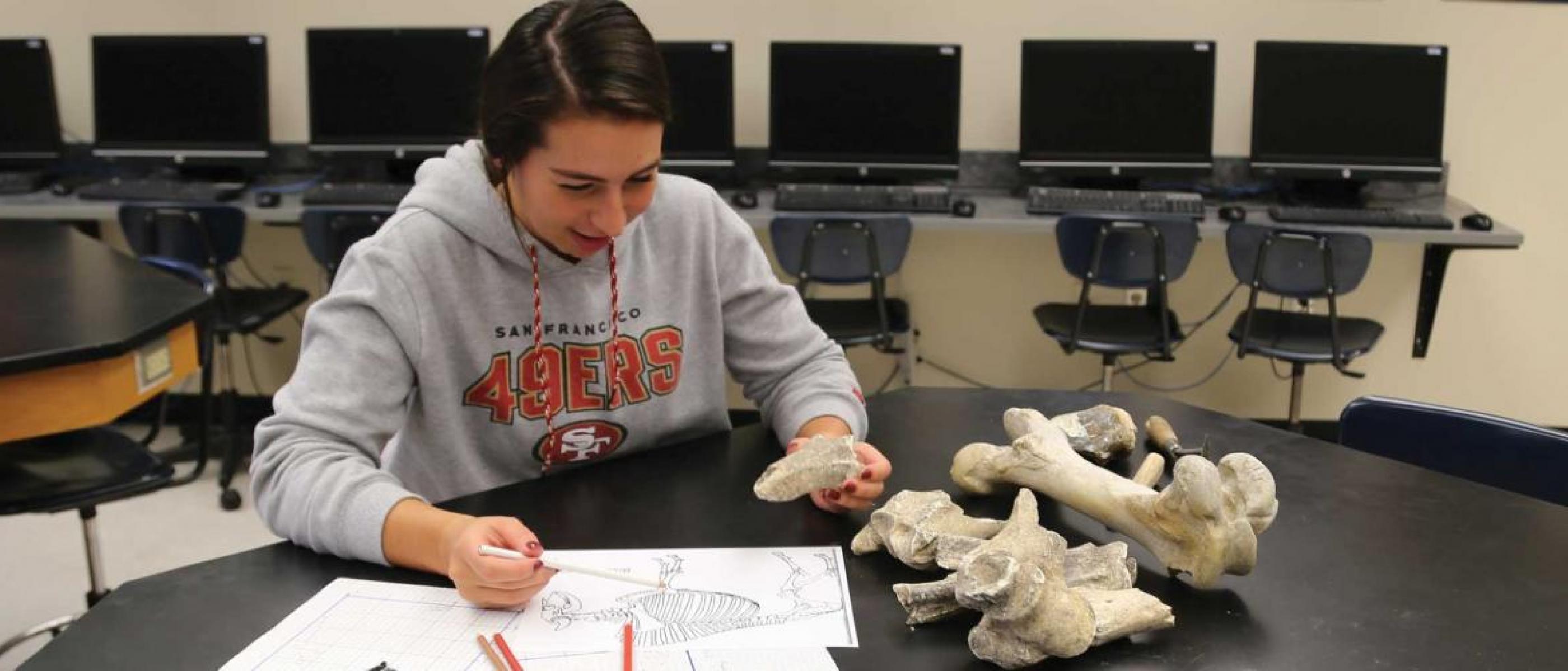 History student at table with papers and fossils