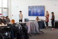 Professor and group of students presenting to local business