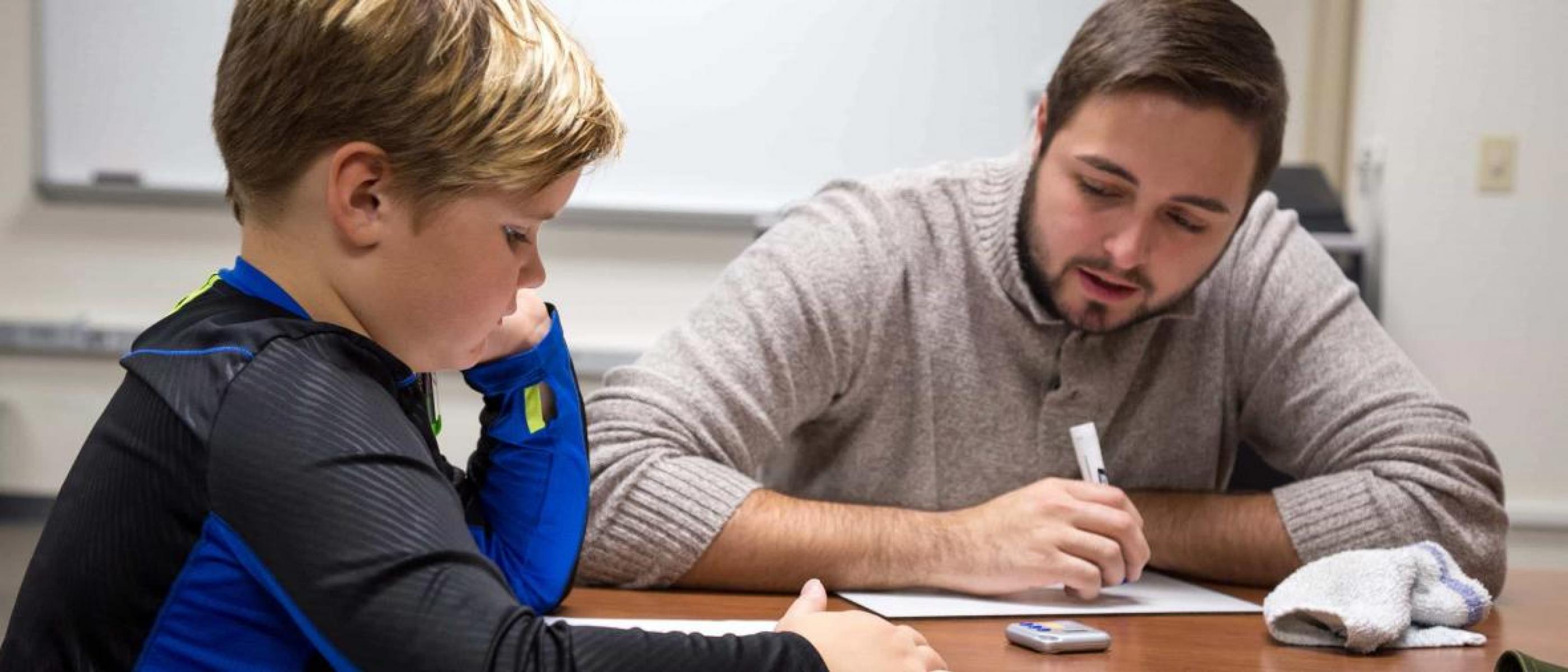 A young student and tutor work in the NSU Reading Clinic