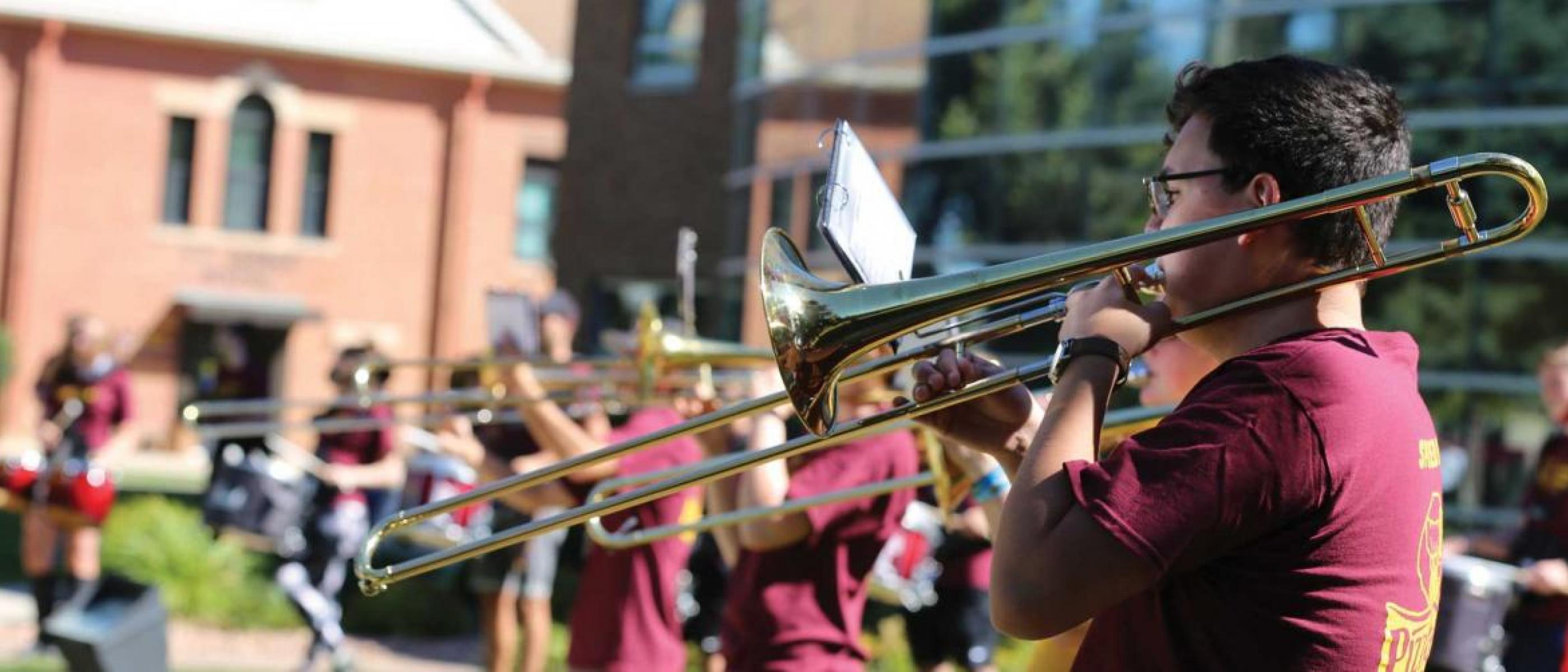 Students playing instruments on campus green
