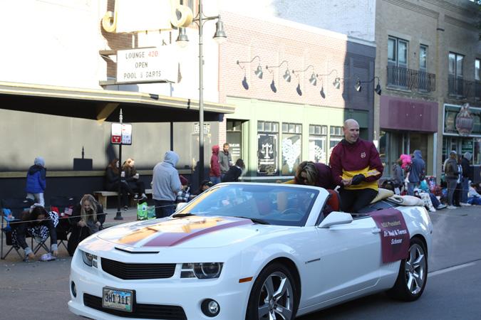 President Schnoor rides in a white convertible in the parade