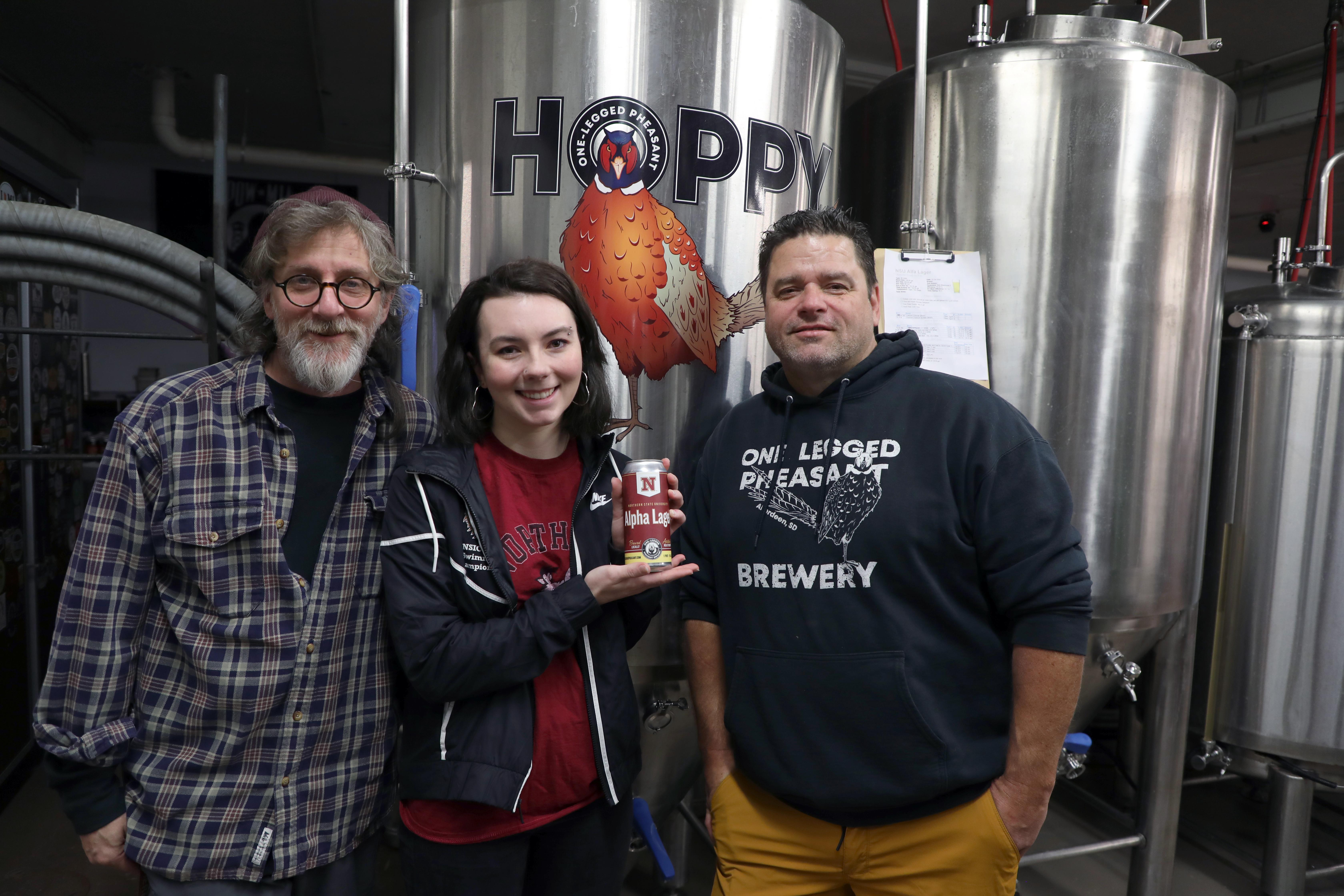 Dr. Jon Mitchell, Kennedy Davis and Dave Welling standing in One Legged Pheasant brewery