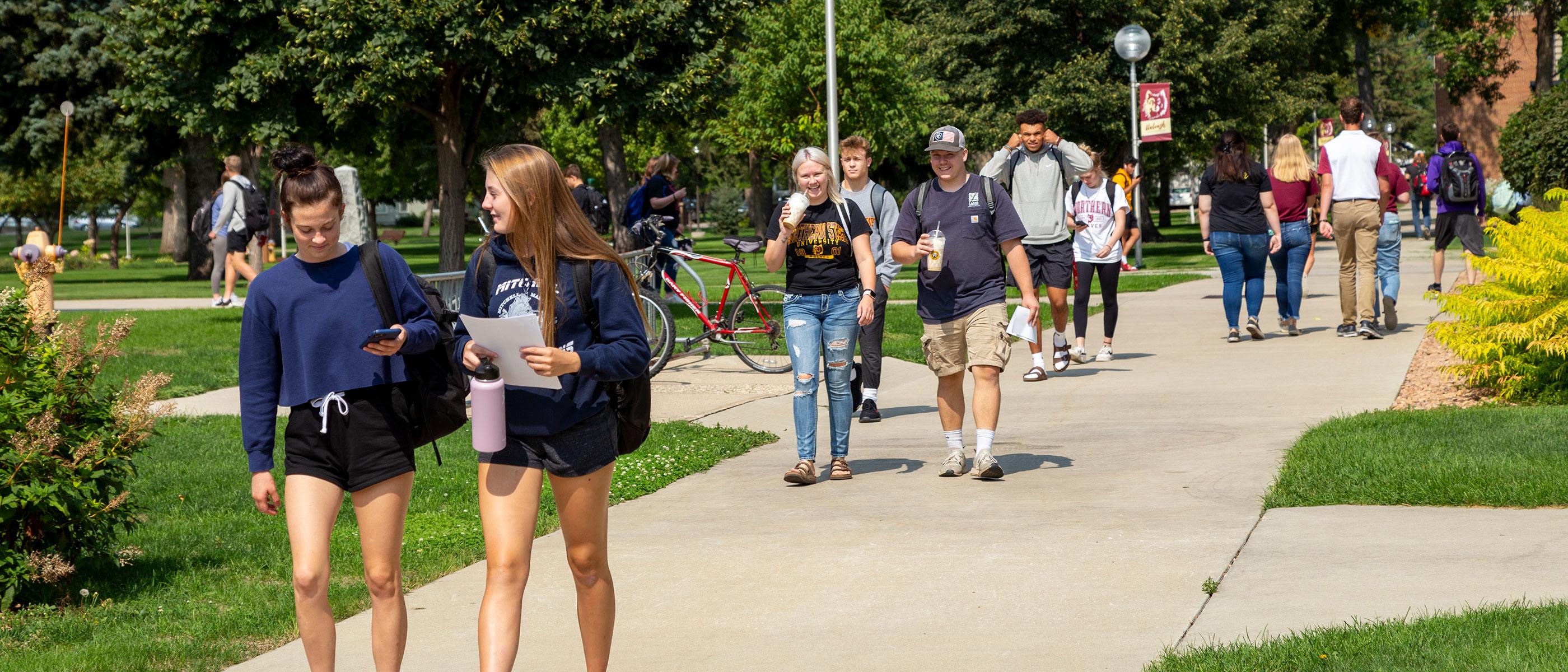 Students walk on the NSU campus green