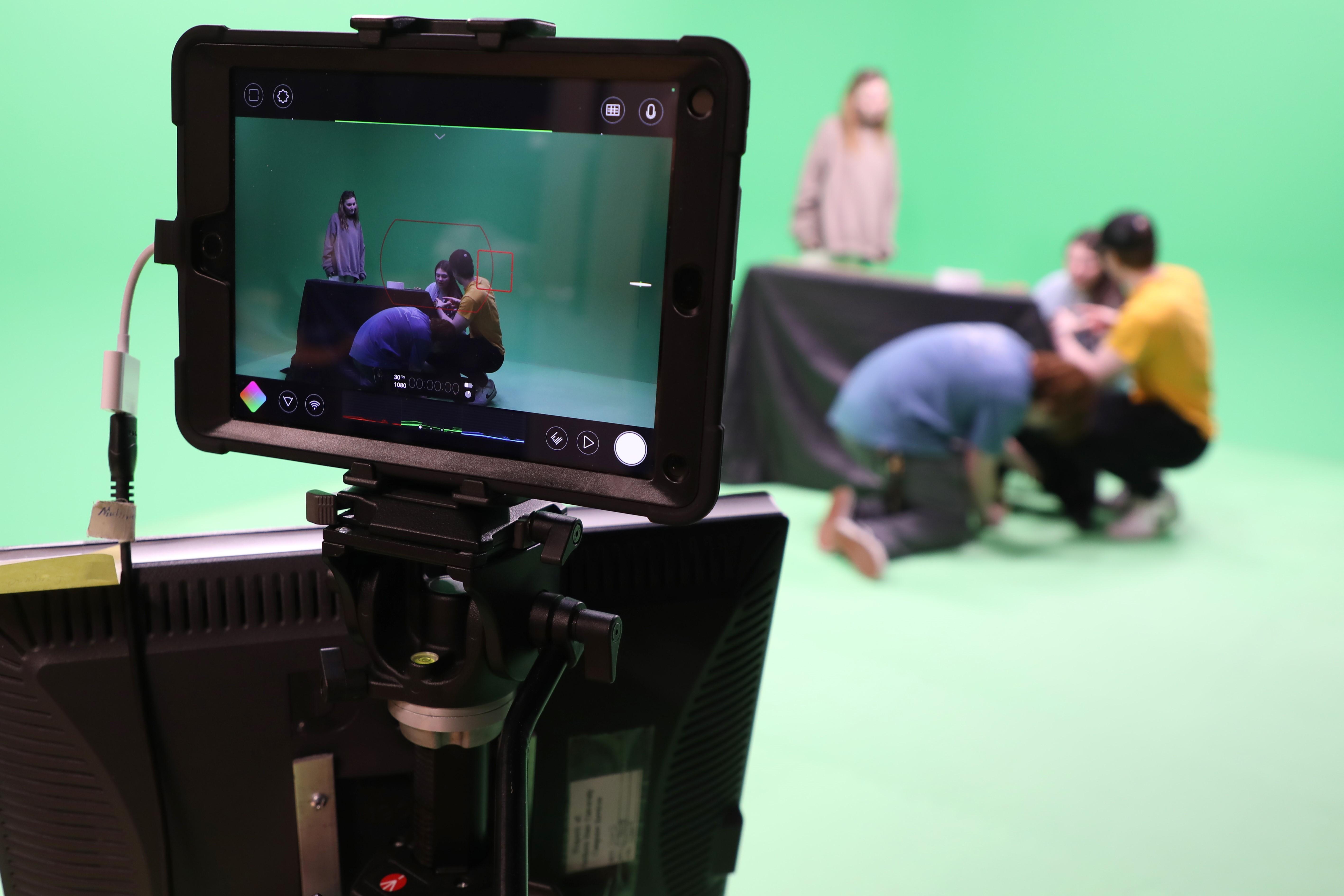 NSU students seen through a video camera lens in front of a green screen in the new Moving Imagery Lab