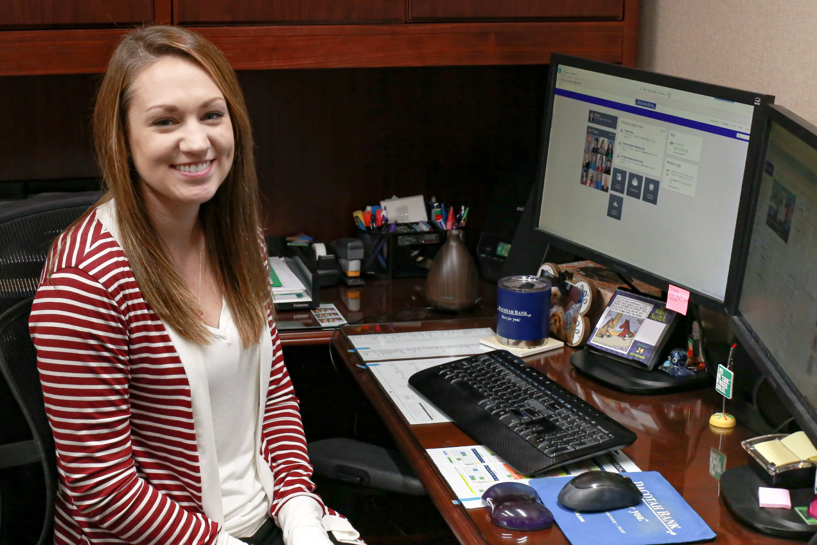 Student intern smiling while working on computer