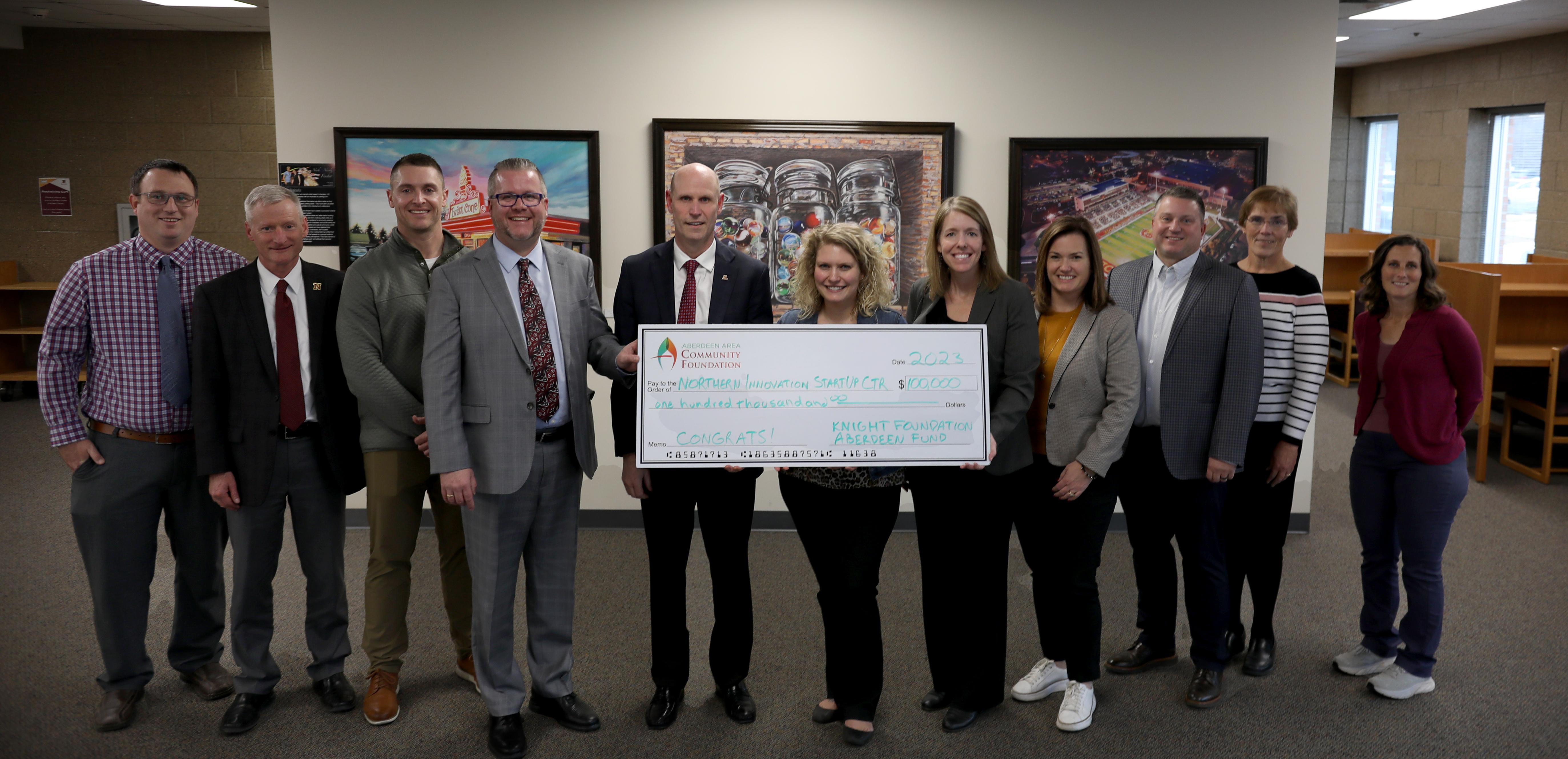 From left, Brock Hoyle, Dr. Mike Wanous, Blake Day, Michael Bockorny, Dr. Neal Schnoor, Bea Smith, Dr. Hannah Walters, Dr. Erin Fouberg, Heath Johnson, Veronica Paulson, and Dr. Alyssa Kiesow hold a check from the Knight Foundation