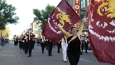 A Marching Wolves flag bearer marches in the homecoming parade