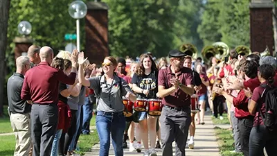 NSU employees lead students between the campus pillars