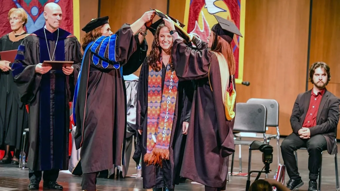 A graduate student receives a degree from Northern
