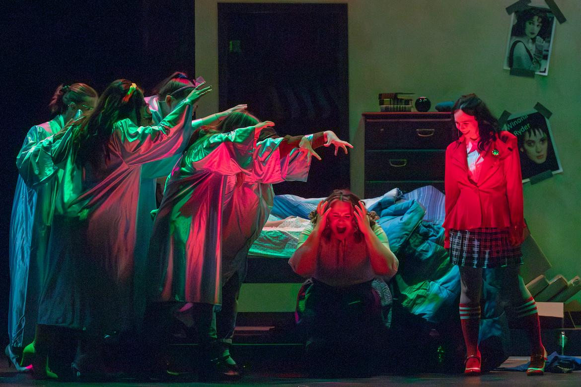 Scene from Heathers the play with ghosts, women screaming and women smiling