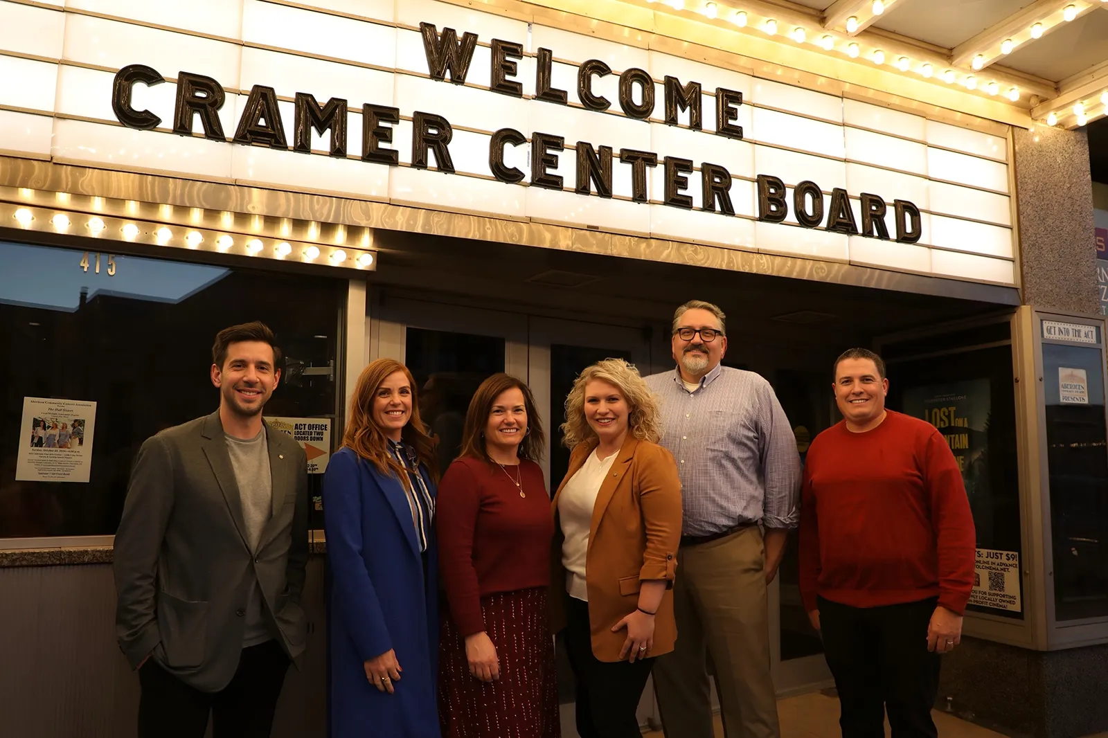Six people standing under a marquee that says - Welcome Cramer Center Board