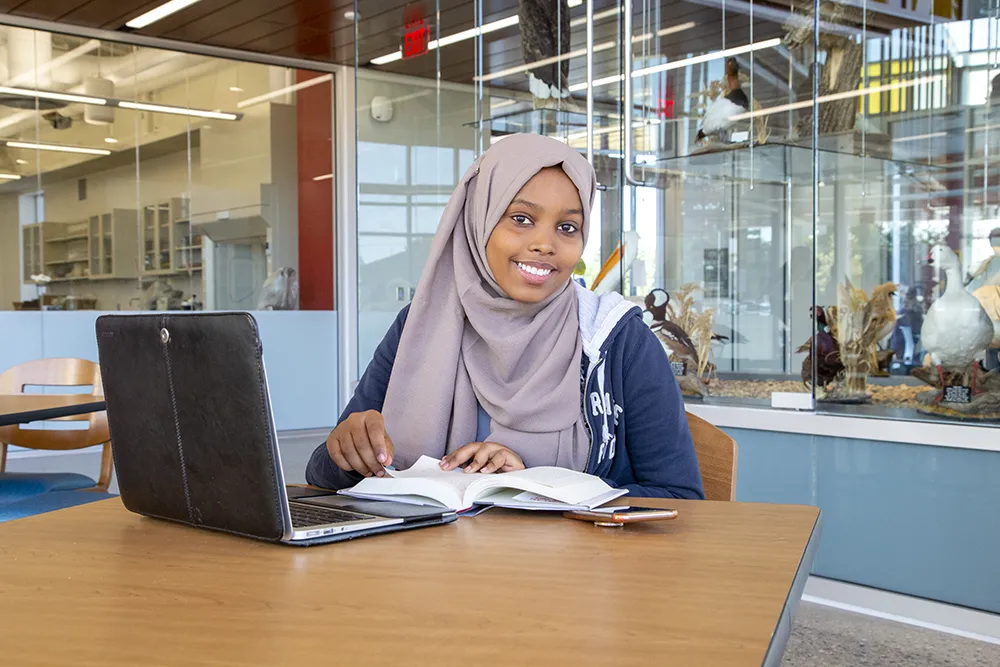 International students smiles while studying in the library