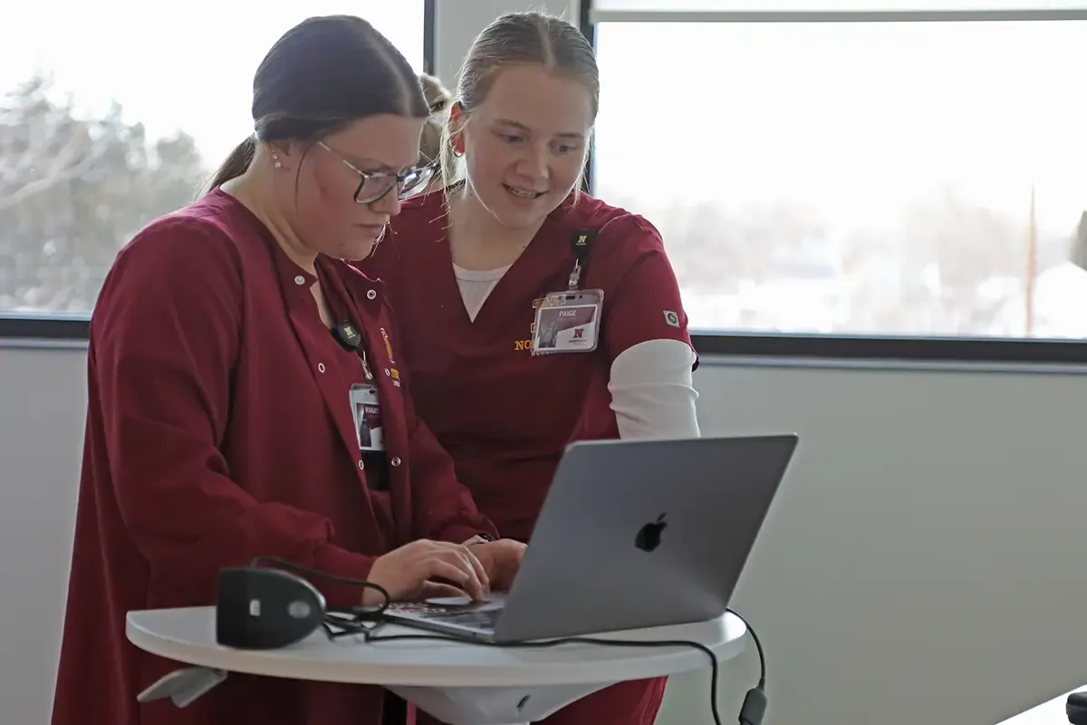 Two nursing students working on a laptop