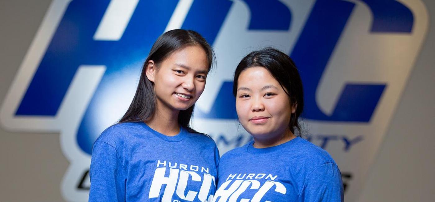 Two students in HCC shirts smile