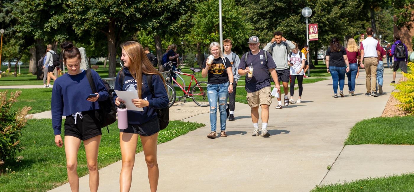 Students walk on the NSU campus green
