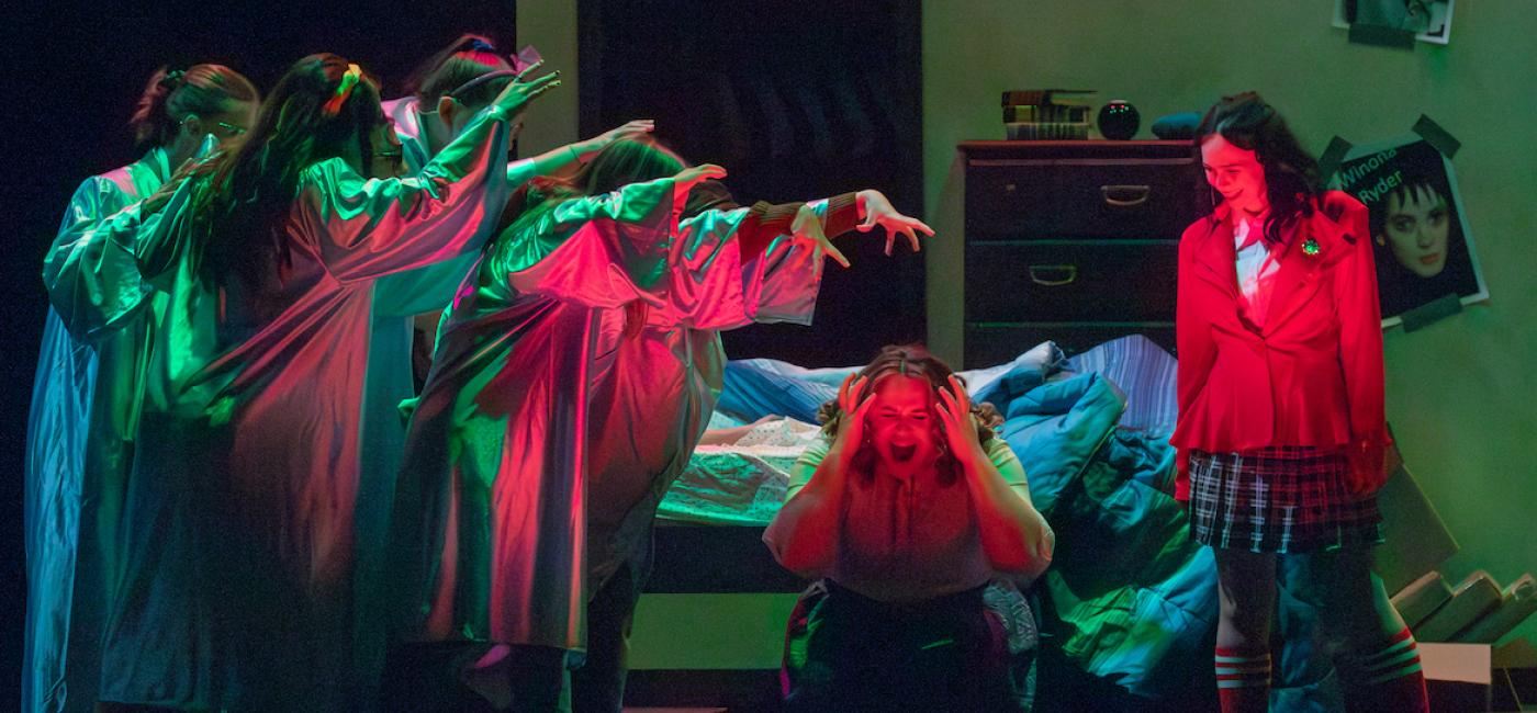 Scene from Heathers the play with ghosts, women screaming and women smiling