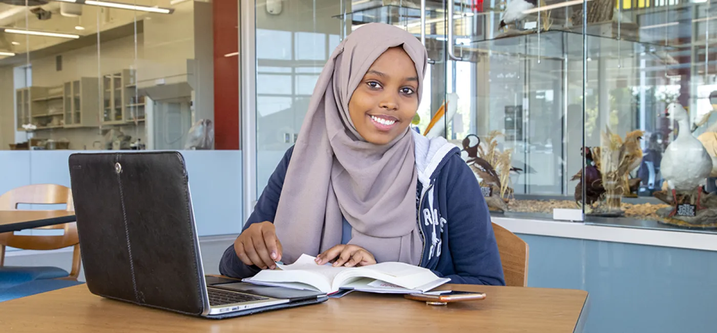 International students smiles while studying in the library