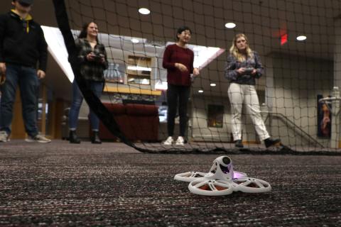A drone with a net and group of people in background