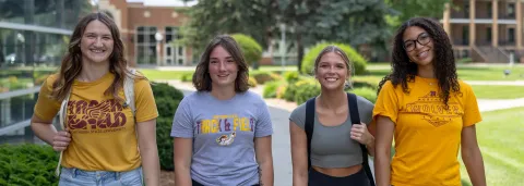 Four new students walking on campus