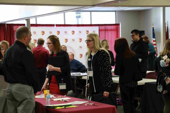 Student talking with employer at job fair