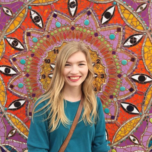 Photo of female student in front of colorful wall art